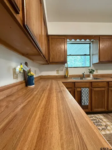 a kitchen with a sink and wooden floor