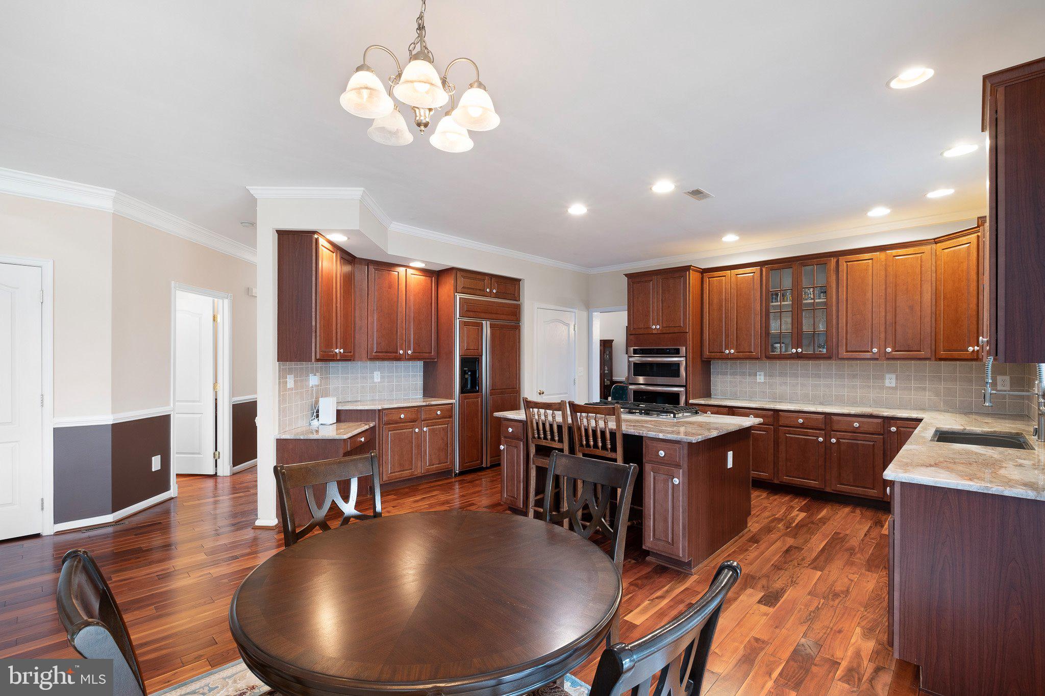 407 Nattull Drive Bear, DE 19701 - Photo 13 of 65 a kitchen with stainless steel appliances kitchen island granite countertop a table chairs sink and cabinets