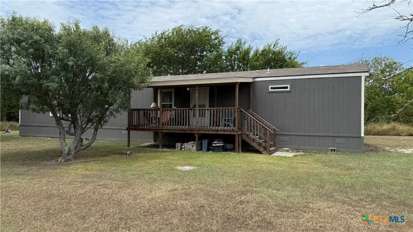 a view of a house with a yard and sitting area