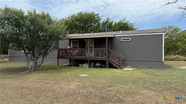 a view of a house with a yard and sitting area