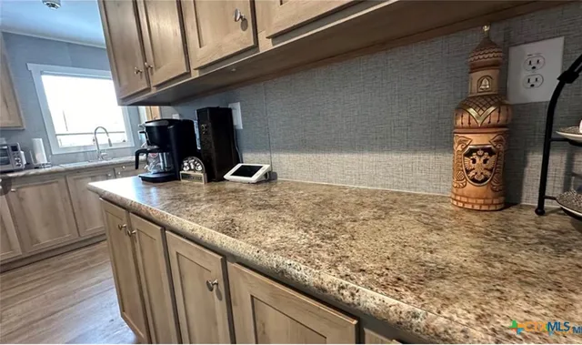 a kitchen with granite countertop a sink a stove and cabinets