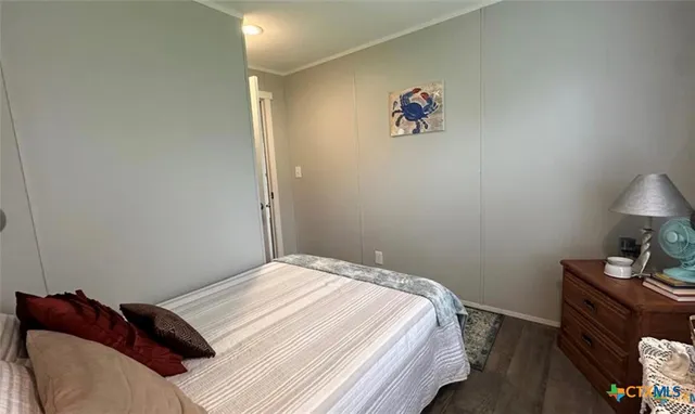 a bedroom with a bed and a lamp on dresser