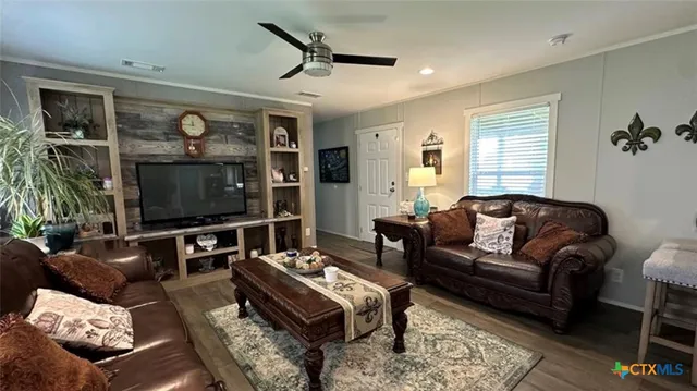 a living room with furniture a flat screen tv and a window