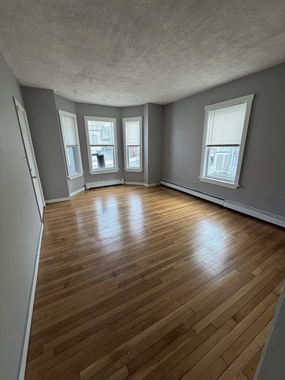 43 Adams Street, Unit 1 Lynn, MA 01902 - Photo 4 of 10 a view of an empty room with wooden floor and window