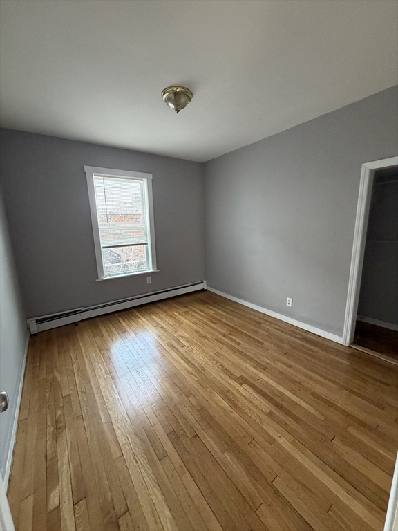 43 Adams Street, Unit 1 Lynn, MA 01902 - Photo 6 of 10 an empty room with wooden floor and windows