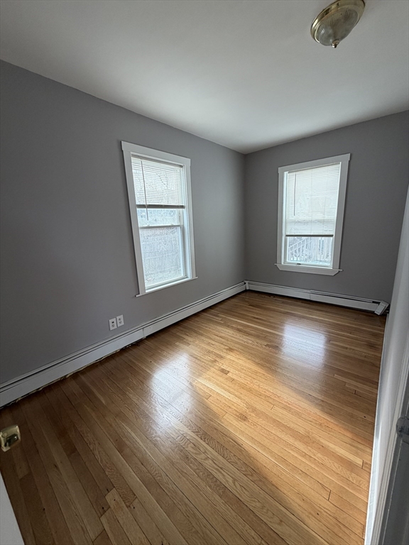 43 Adams Street, Unit 1 Lynn, MA 01902 - Photo 7 of 10 an empty room with wooden floor and windows