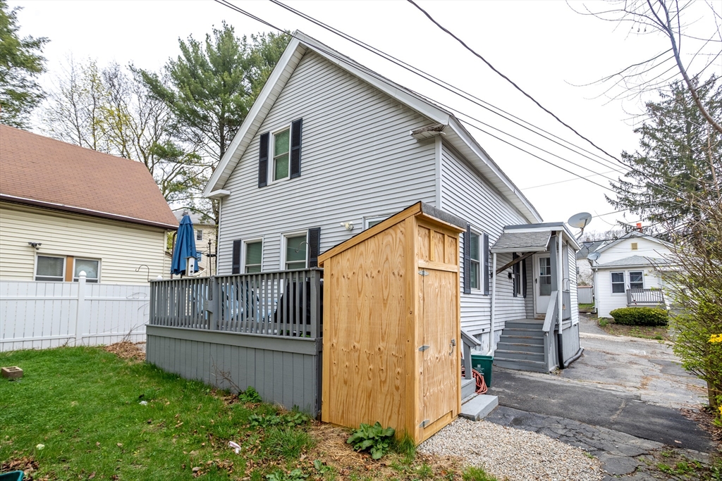 663 Millbury Street Worcester, MA 01607 - Photo 1 of 32 a view of a white house with a large tree and wooden fence
