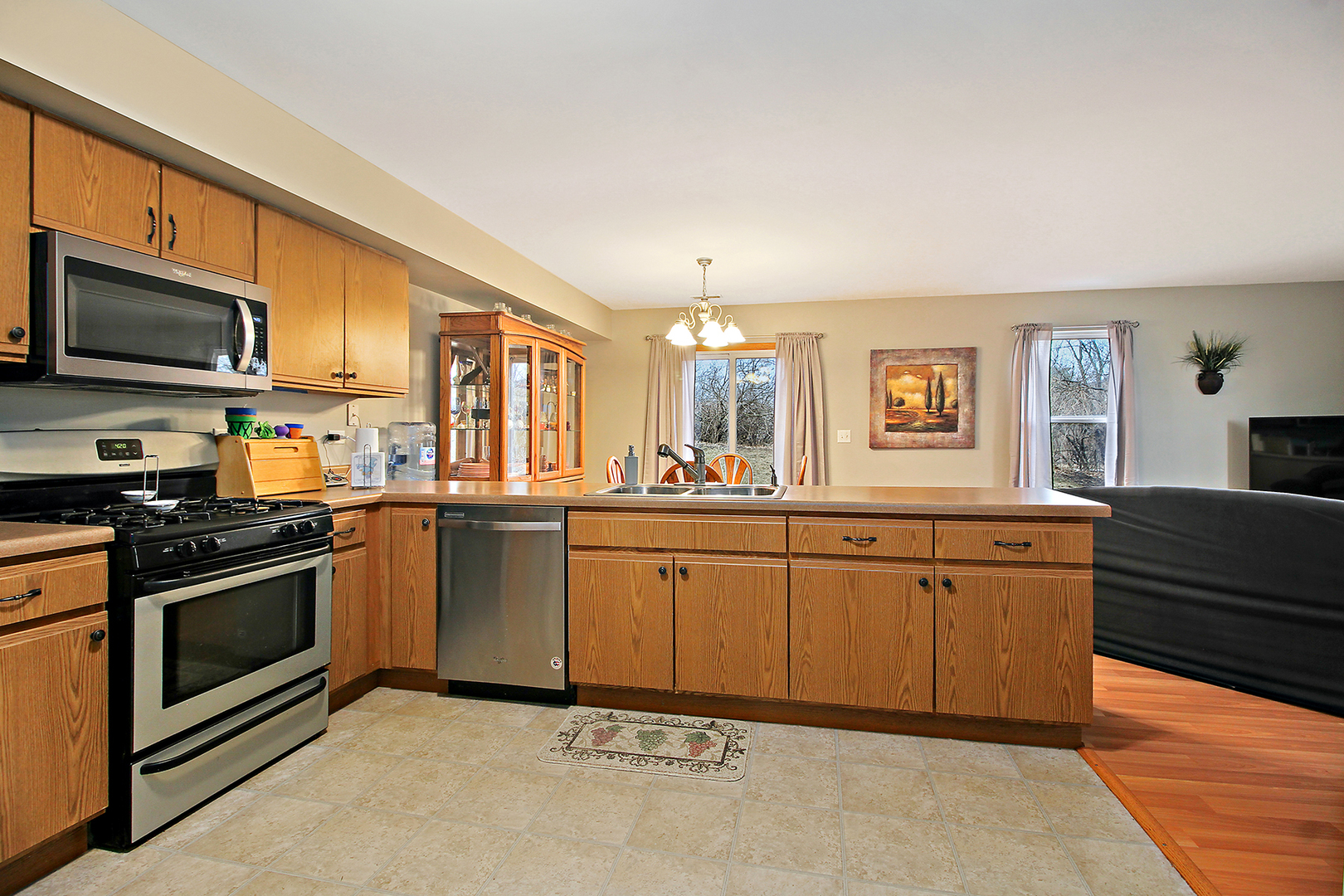 25265 Faraday Road, Unit 25265 Manhattan, IL 60442 - Photo 6 of 15 a kitchen with stainless steel appliances granite countertop a stove top oven a sink dishwasher and a microwave oven with white cabinets