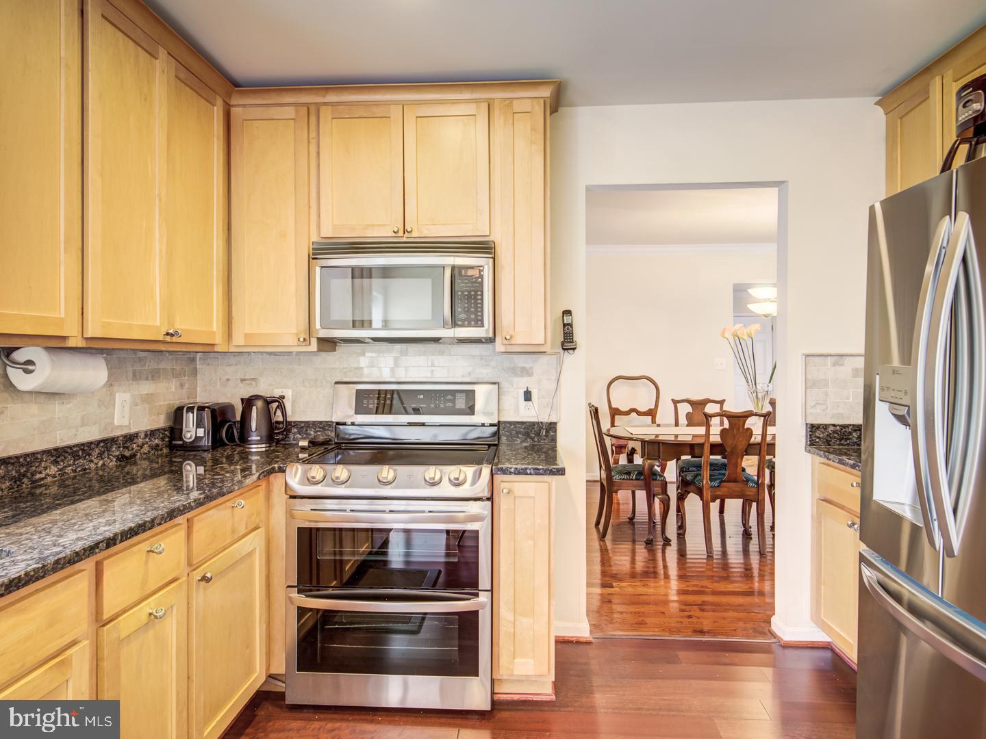 19400 White Ground Road Boyds, MD 20841 - Photo 18 of 59 a kitchen with stainless steel appliances granite countertop a stove top oven a sink and a microwave