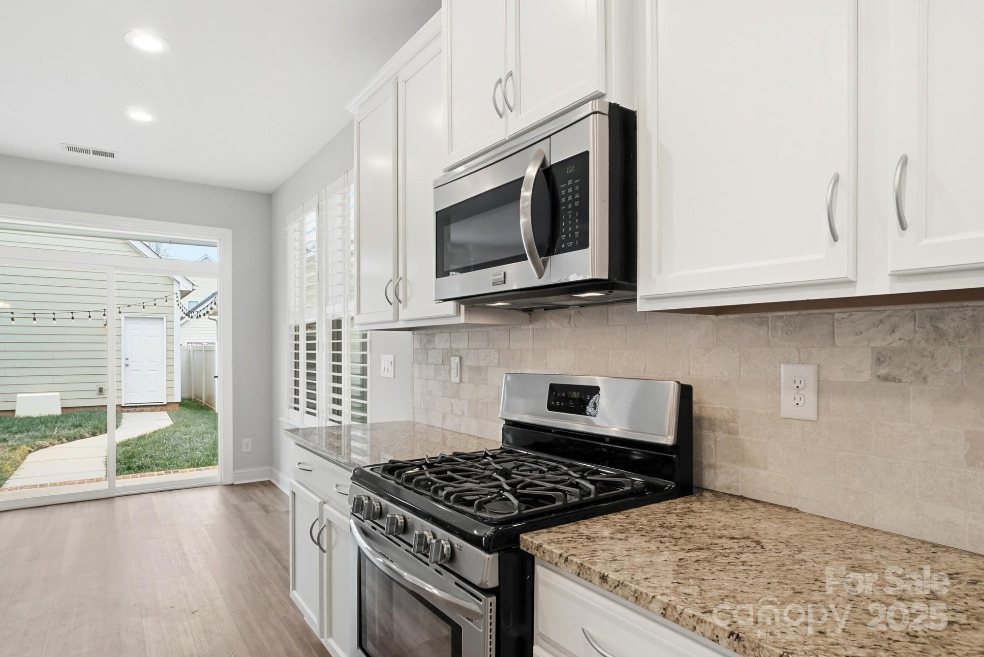 1012 Back Stretch Boulevard Indian Trail, NC 28079 - Photo 17 of 48 a kitchen with stainless steel appliances granite countertop white cabinets and a stove top oven