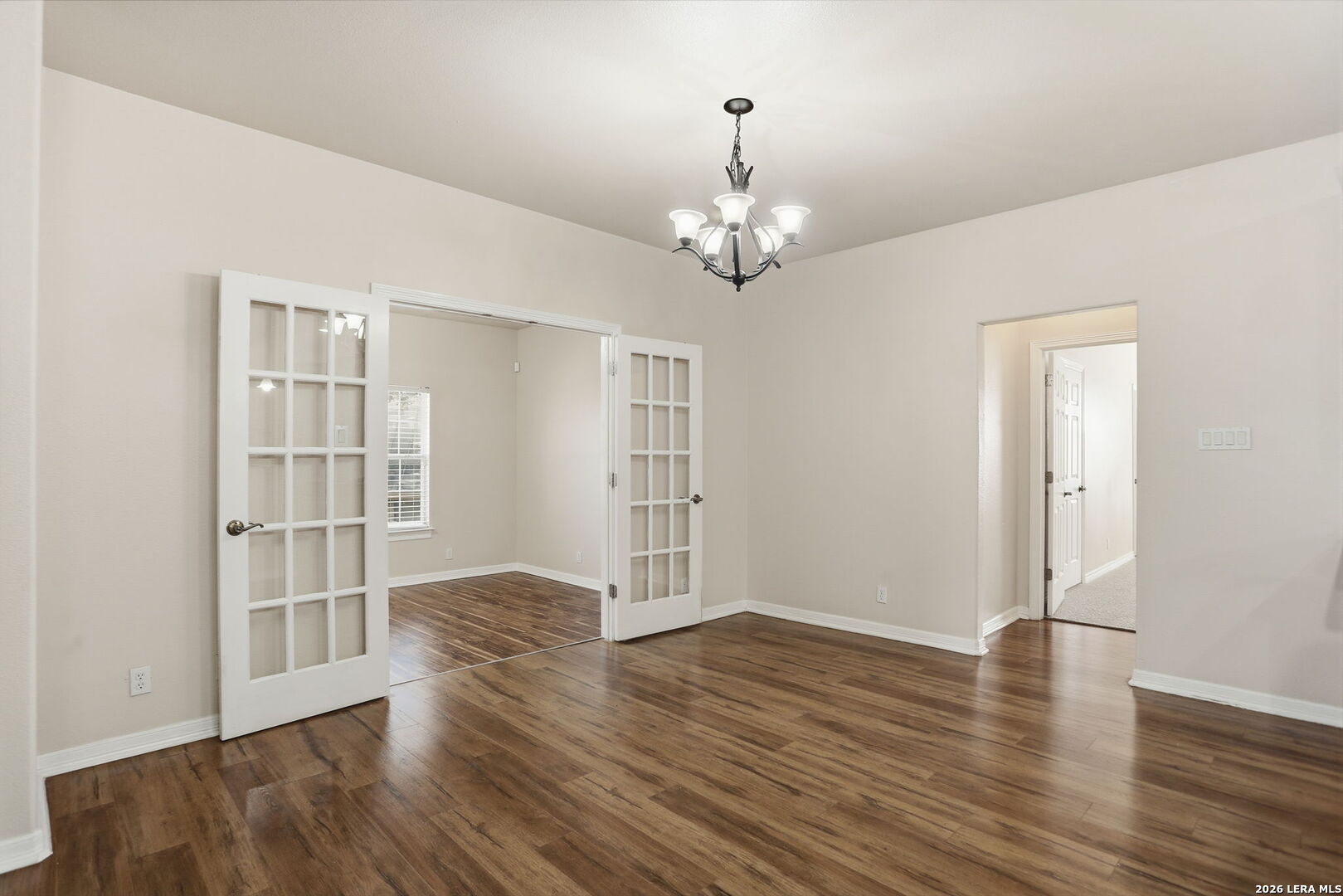 8814 Spanish Moss Windcrest, TX 78239 - Photo 14 of 50 an empty room with wooden floor and chandelier