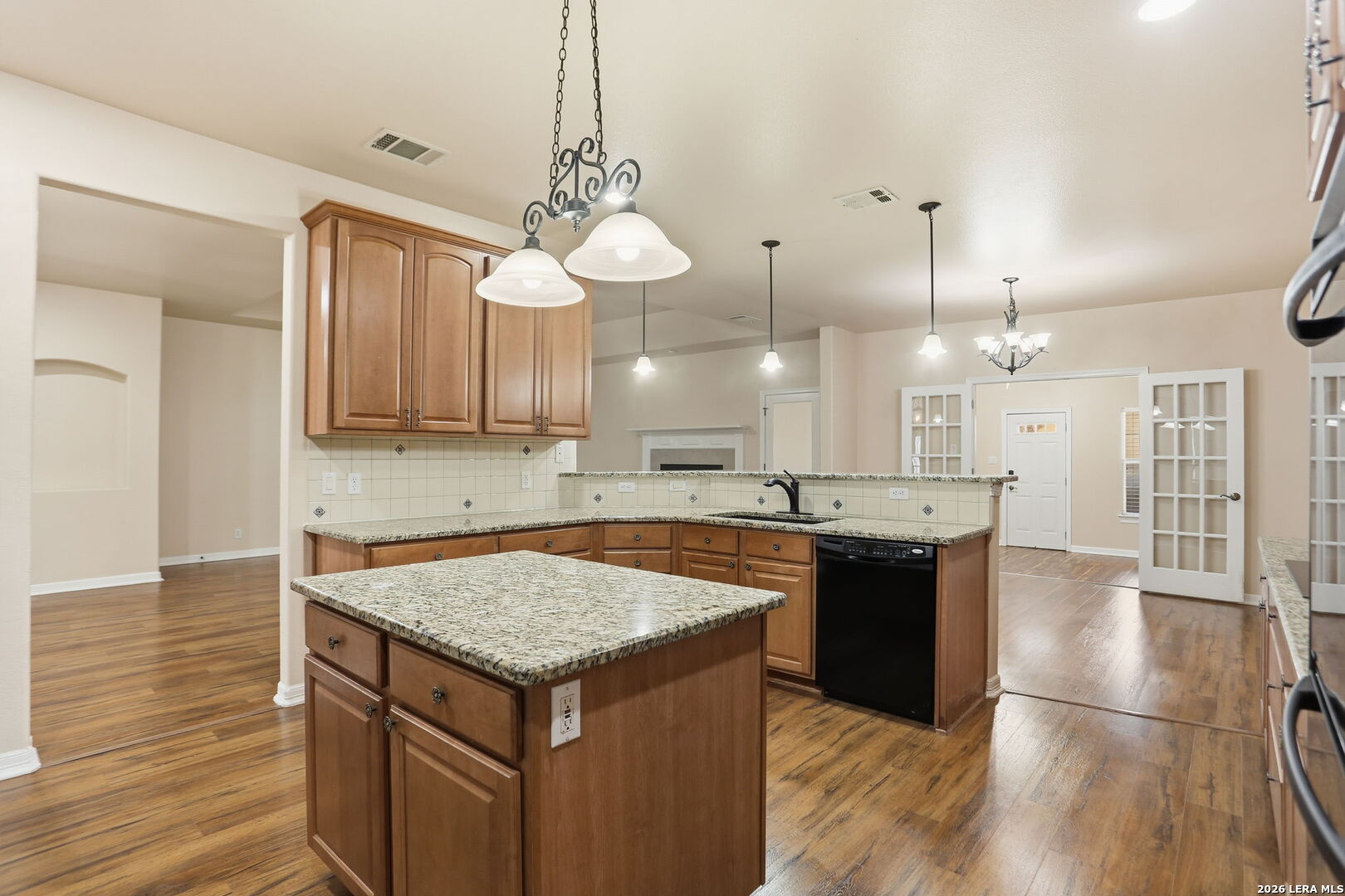 8814 Spanish Moss Windcrest, TX 78239 - Photo 19 of 50 a kitchen with a center island wooden floor and a refrigerator