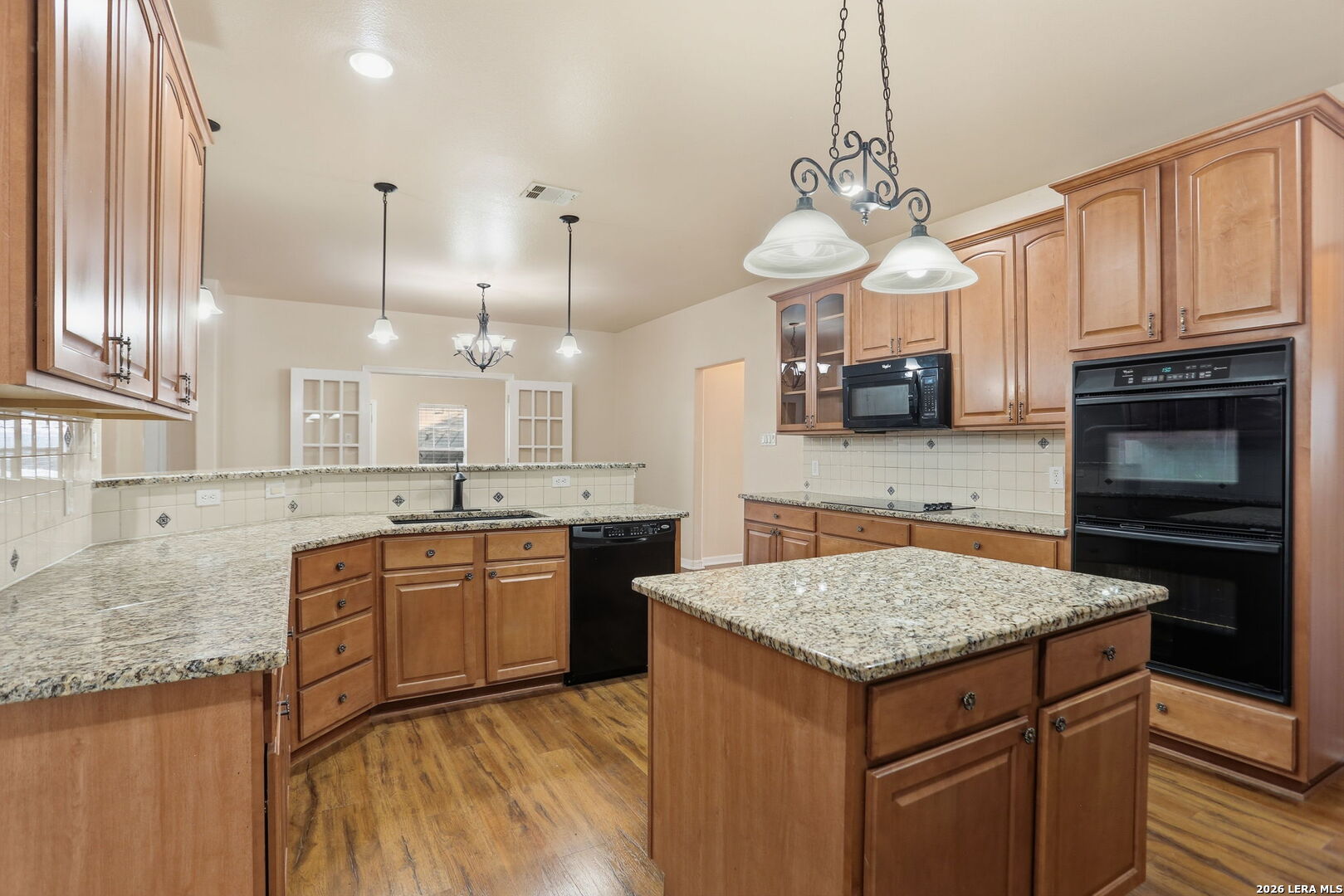 8814 Spanish Moss Windcrest, TX 78239 - Photo 20 of 50 a kitchen with kitchen island granite countertop wooden cabinets and a stove