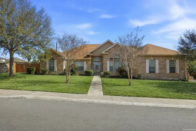 a view of a big house with a big yard and large trees