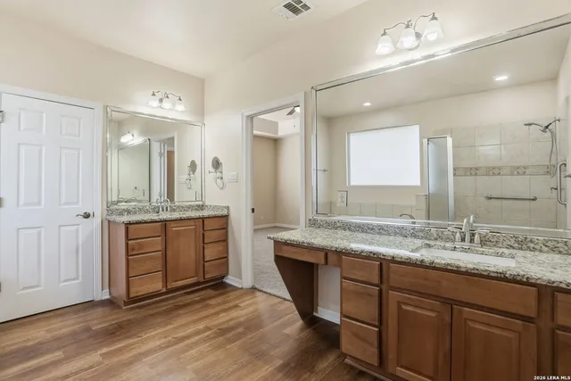 a spacious bathroom with a granite countertop sink mirror and a