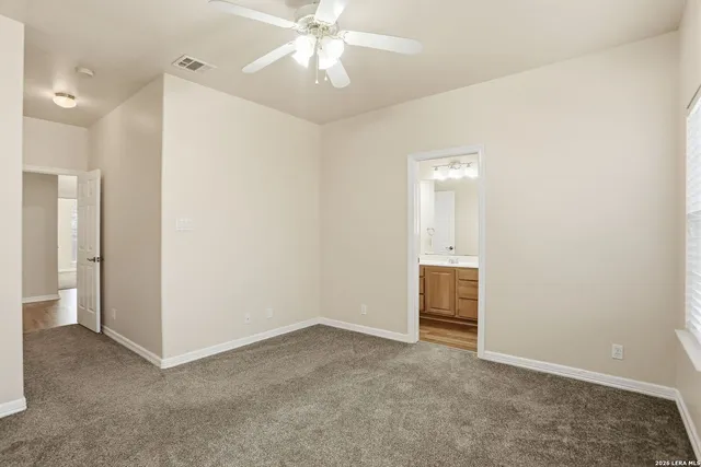 an empty room with closet and a ceiling fan