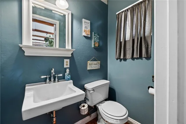 a bathroom with a toilet a sink and mirror