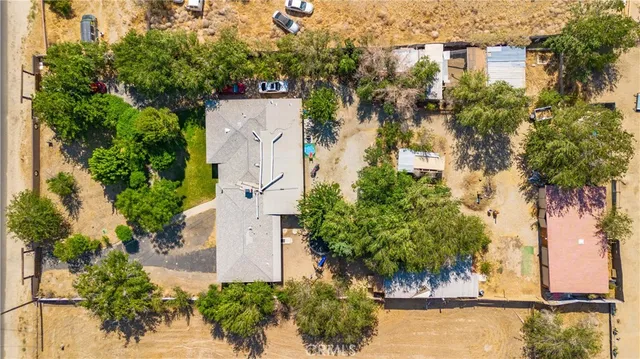 an aerial view of residential houses with outdoor space and trees all around