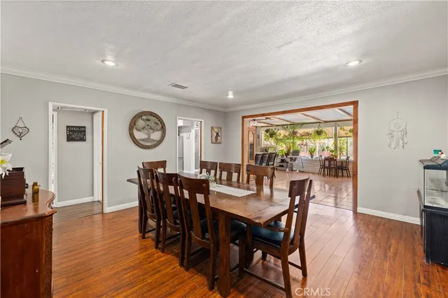 a view of a dining room and livingroom with furniture window and wooden floor