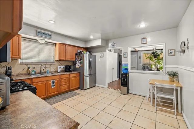 a large kitchen with a stove a refrigerator and a sink