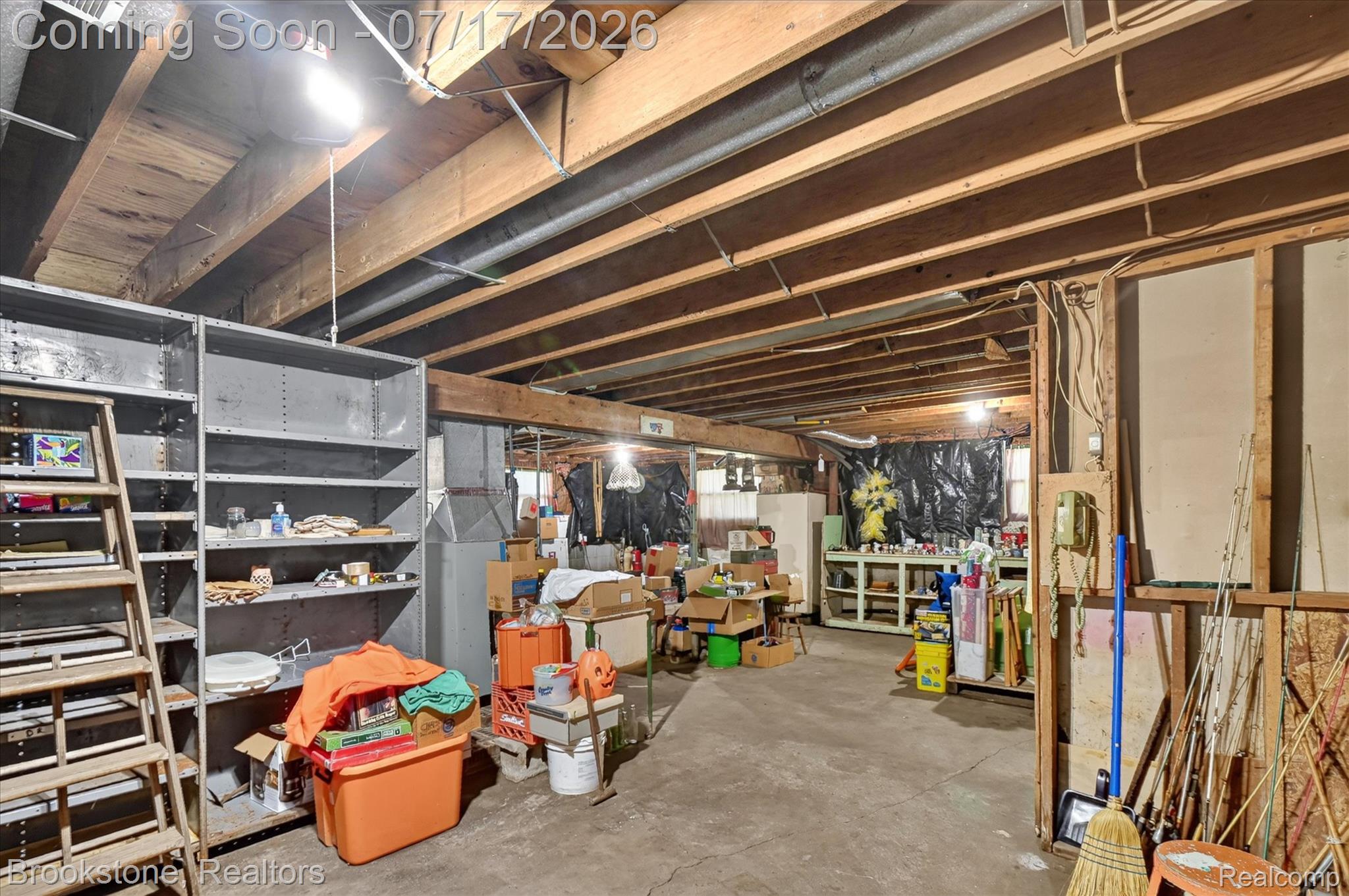 22025 Lakefield Road Merrill, MI 48637 - Photo 33 of 47 Unfinished basement featuring exposed wood joists, concrete flooring, and metal shelving units