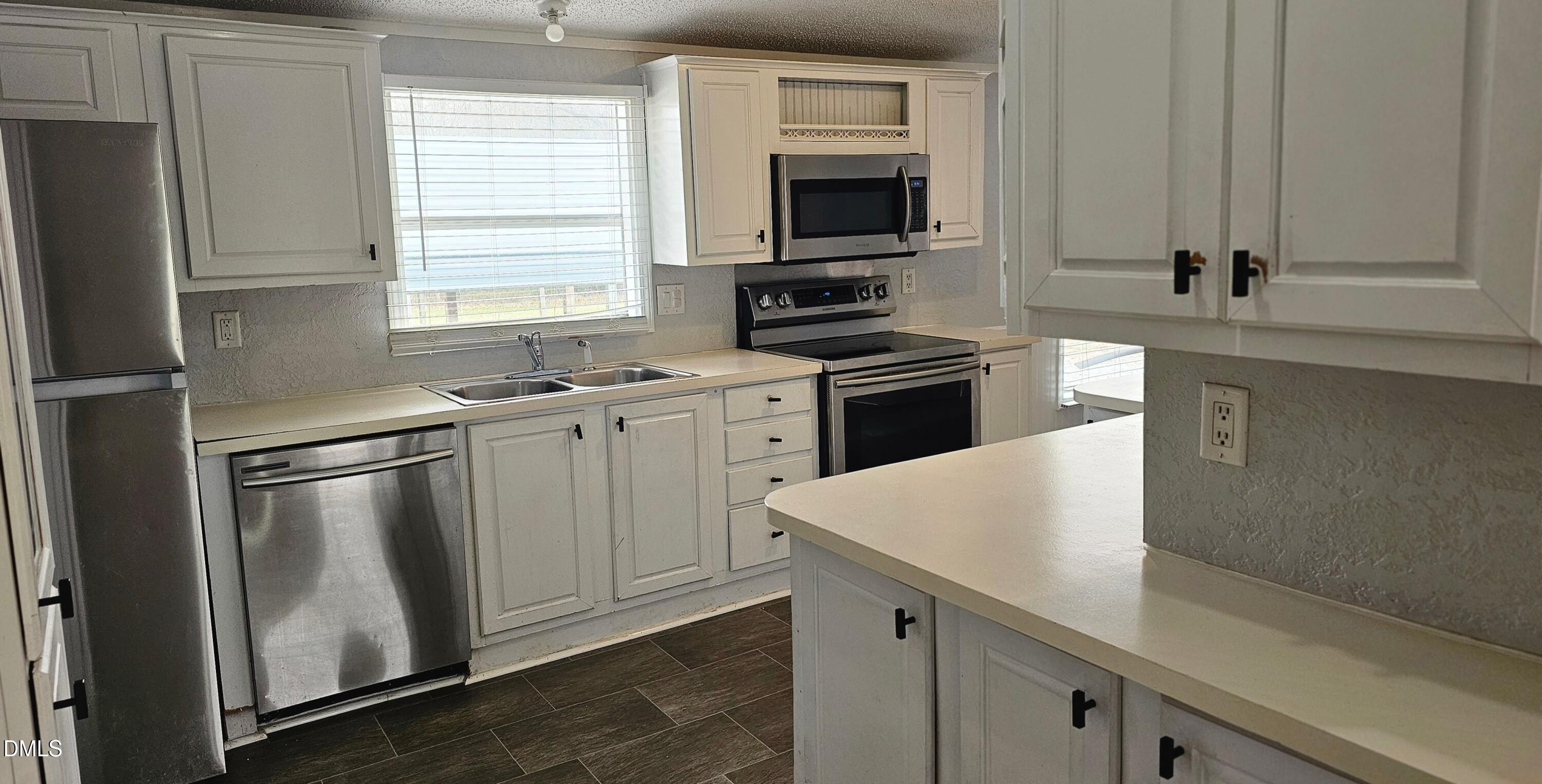 4762 Old Allensville Road Roxboro, NC 27574 - Photo 18 of 33 a kitchen with stainless steel appliances a sink stove and microwave