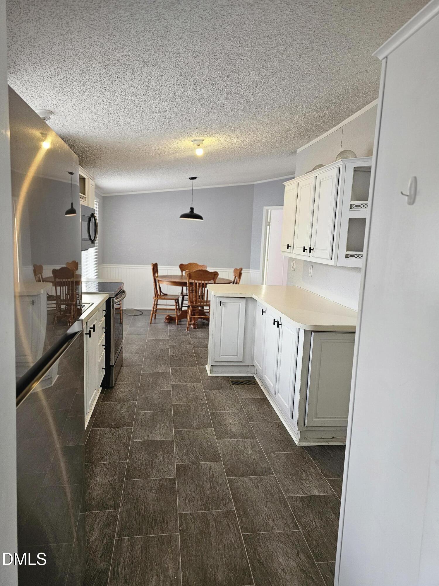 4762 Old Allensville Road Roxboro, NC 27574 - Photo 20 of 33 a large kitchen with stainless steel appliances a stove a sink dishwasher and cabinets