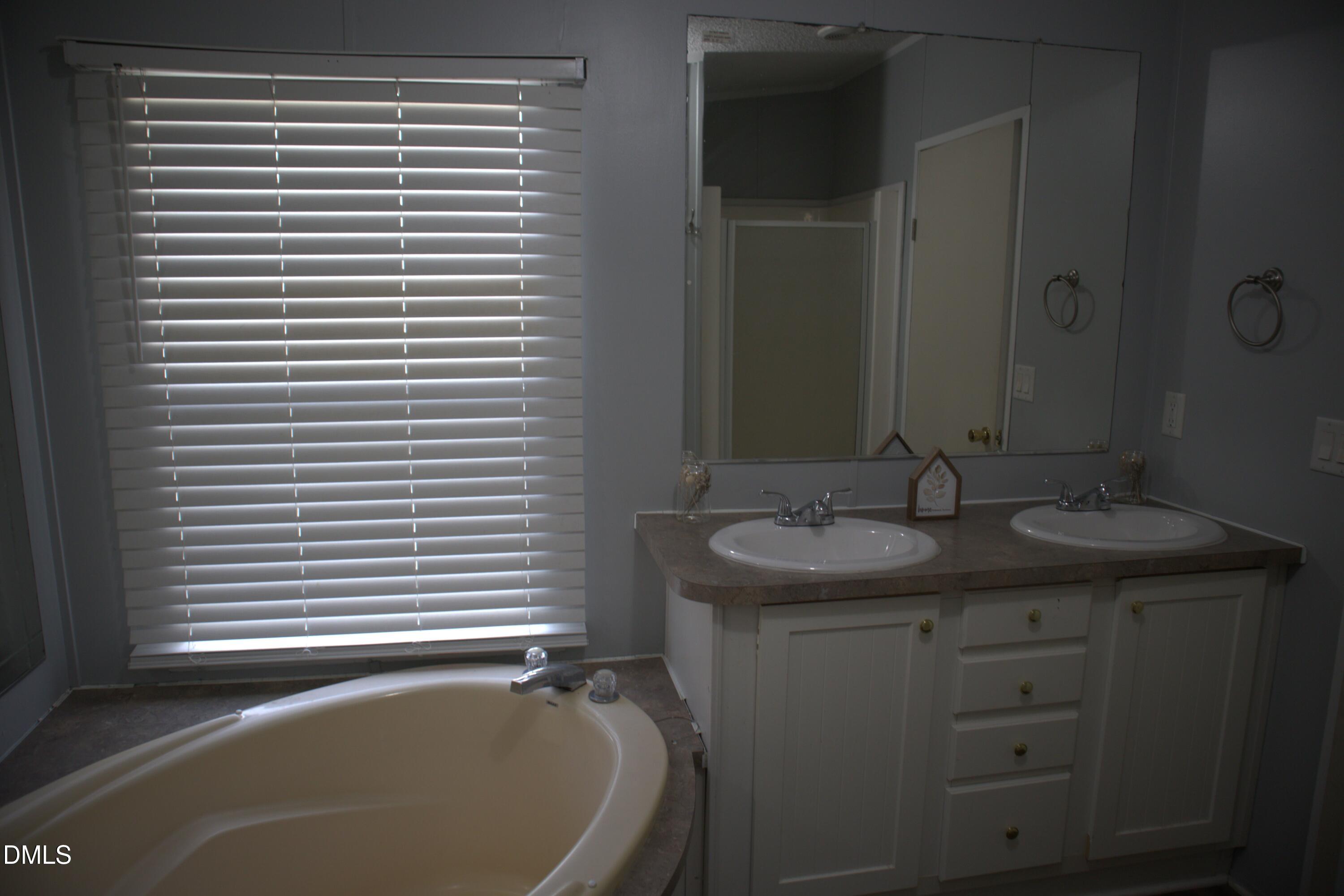 4762 Old Allensville Road Roxboro, NC 27574 - Photo 26 of 33 a bathroom with a granite countertop sink and a bathtub
