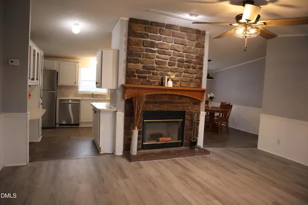 a view of a livingroom with a fireplace and chandelier fan