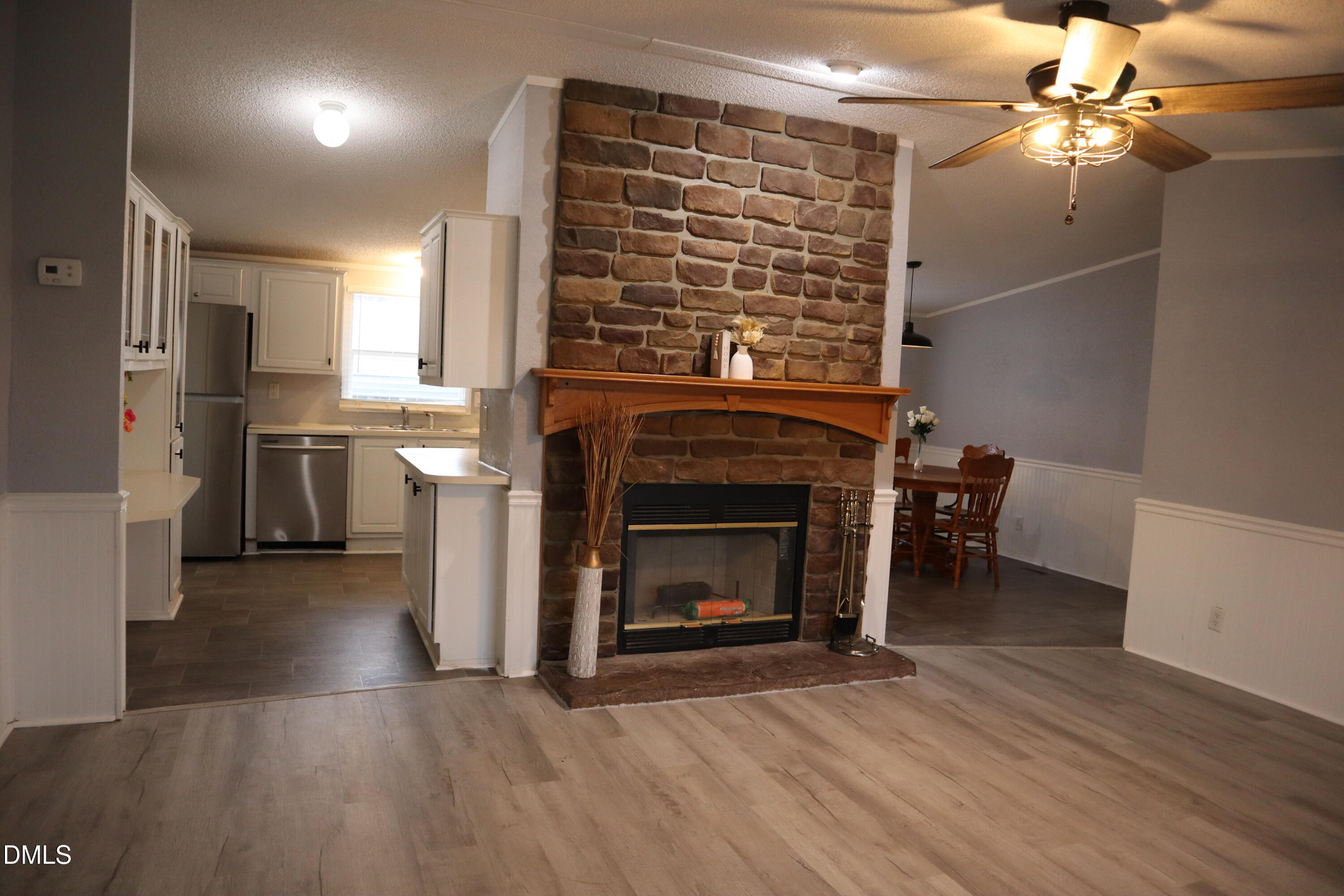 4762 Old Allensville Road Roxboro, NC 27574 - Photo 5 of 33 a view of a livingroom with a fireplace and chandelier fan
