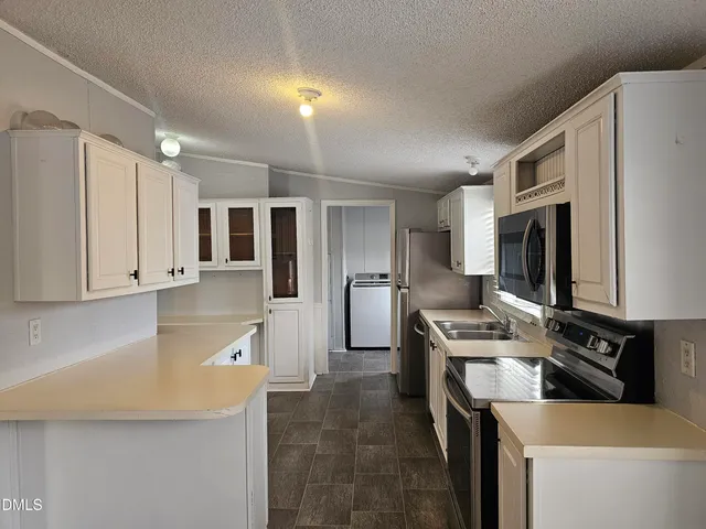 a kitchen that has a lot of cabinets a sink and a stove in it