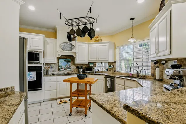 a kitchen with stainless steel appliances granite countertop a sink a stove and cabinets