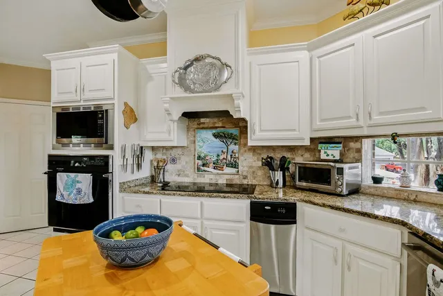 a kitchen with stainless steel appliances granite countertop a stove a microwave a refrigerator and cabinets