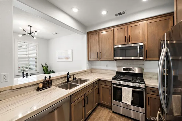 a kitchen with stainless steel appliances a sink a stove and microwave