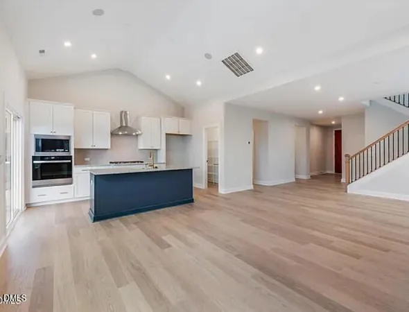 a kitchen with granite countertop a sink stainless steel appliances and cabinets