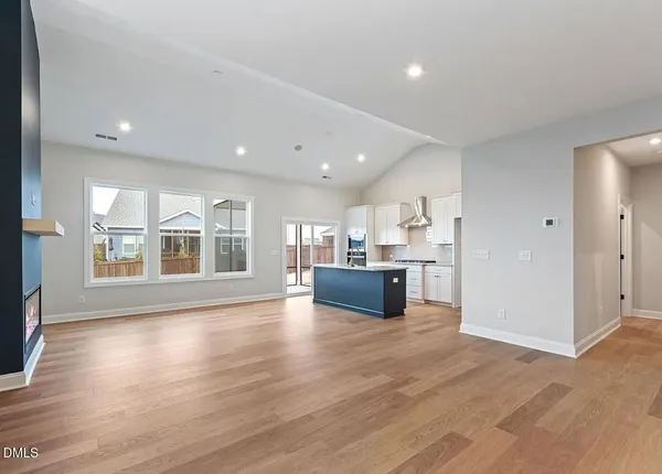 a large kitchen with stainless steel appliances kitchen island granite countertop a large counter top and a stove with wooden floor