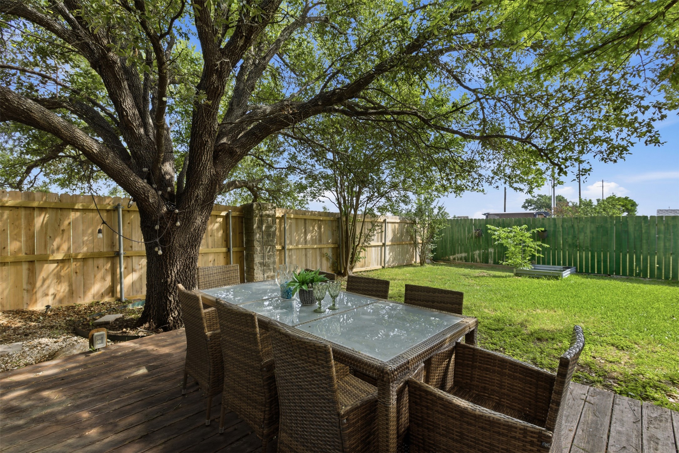 112 Prairie Springs Loop Georgetown, TX 78626 - Photo 18 of 23 a view of a backyard with table and chairs and couches with wooden fence and large trees