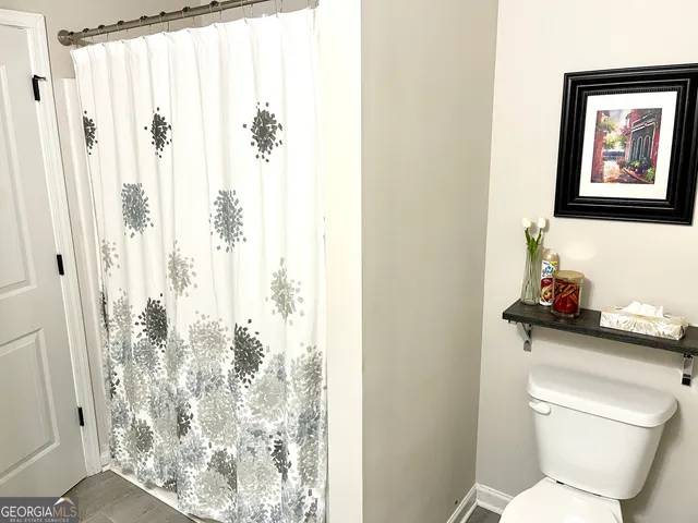 a bathroom with a toilet and a shower curtain