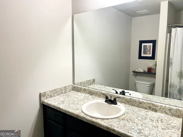 a bathroom with a granite countertop sink and a mirror