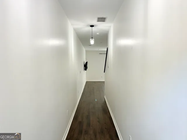 a view of a hallway with wooden floor and staircase