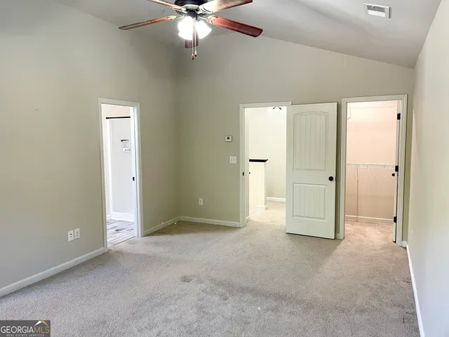 an empty room with fan and entrance