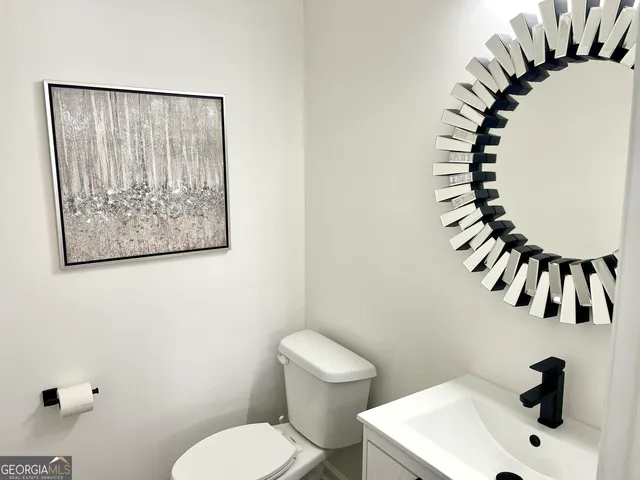 a bathroom with a sink mirror and toilet