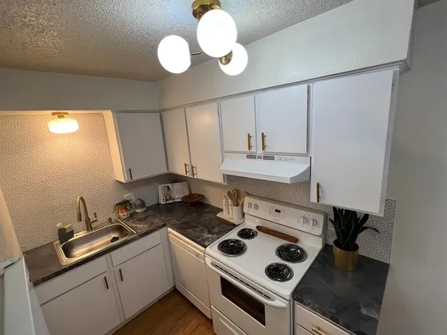 a kitchen with a sink stove and cabinets