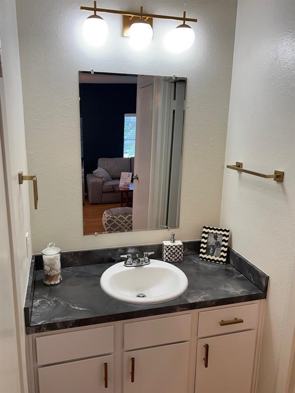 4209 Avenue B, Unit 203 Austin, TX 78751 - Photo 6 of 6 a bathroom with a granite countertop sink and a mirror