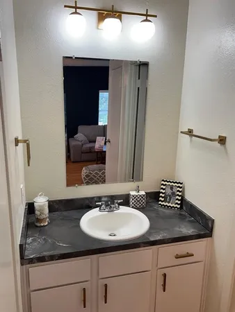 a bathroom with a granite countertop sink and a mirror