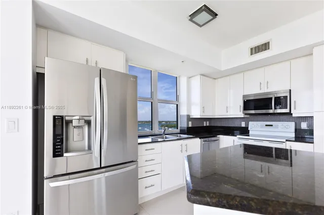 a kitchen with stainless steel appliances granite countertop a refrigerator and a stove