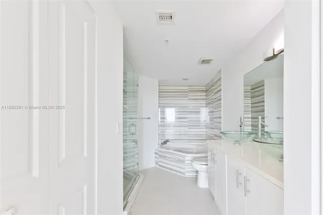 a bathroom with a double vanity sink toilet and a mirror