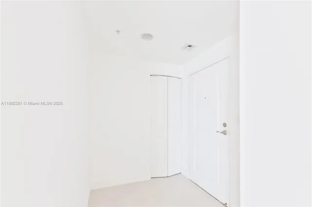 a view of a kitchen with refrigerator and window