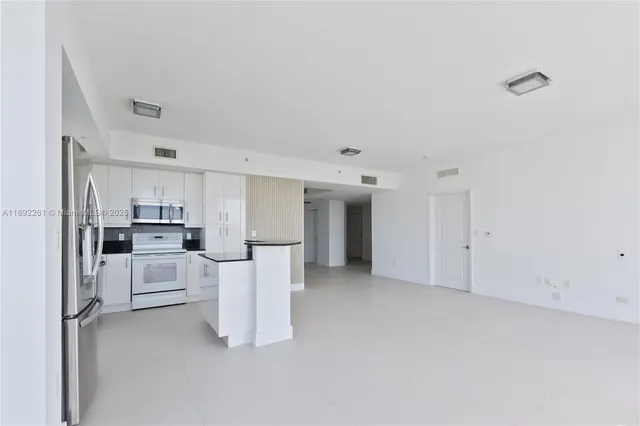 a kitchen with stainless steel appliances granite countertop a sink and a refrigerator