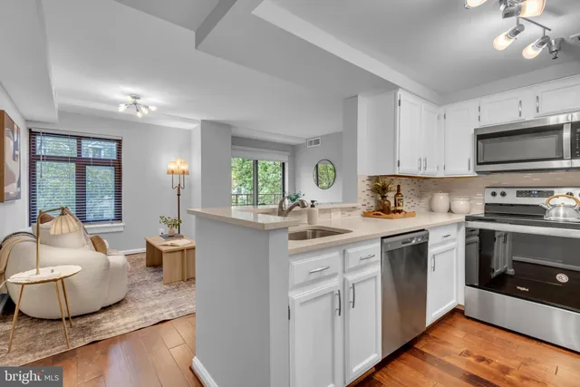 a kitchen with sink a microwave and cabinets